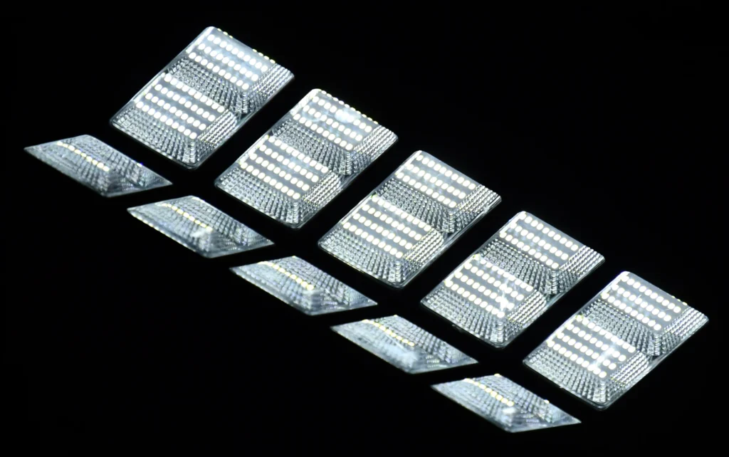A row of bright rectangular LED lights is illuminated against a black background.
